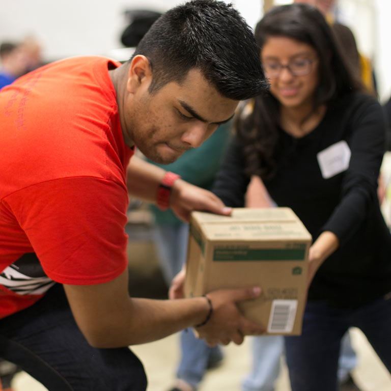 A person hands a box to another person.