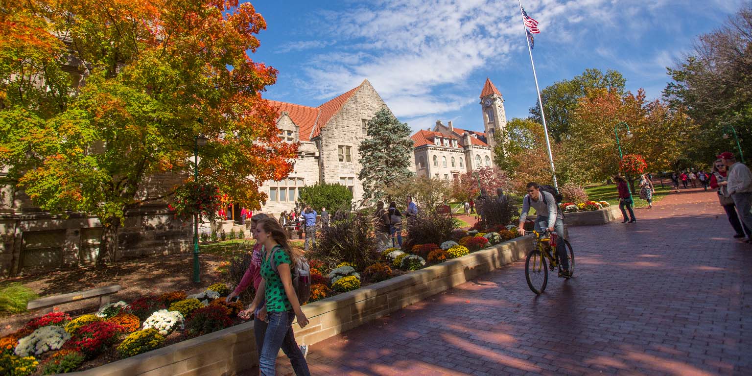 Students walk past the Student Building on a sunny autumn day.